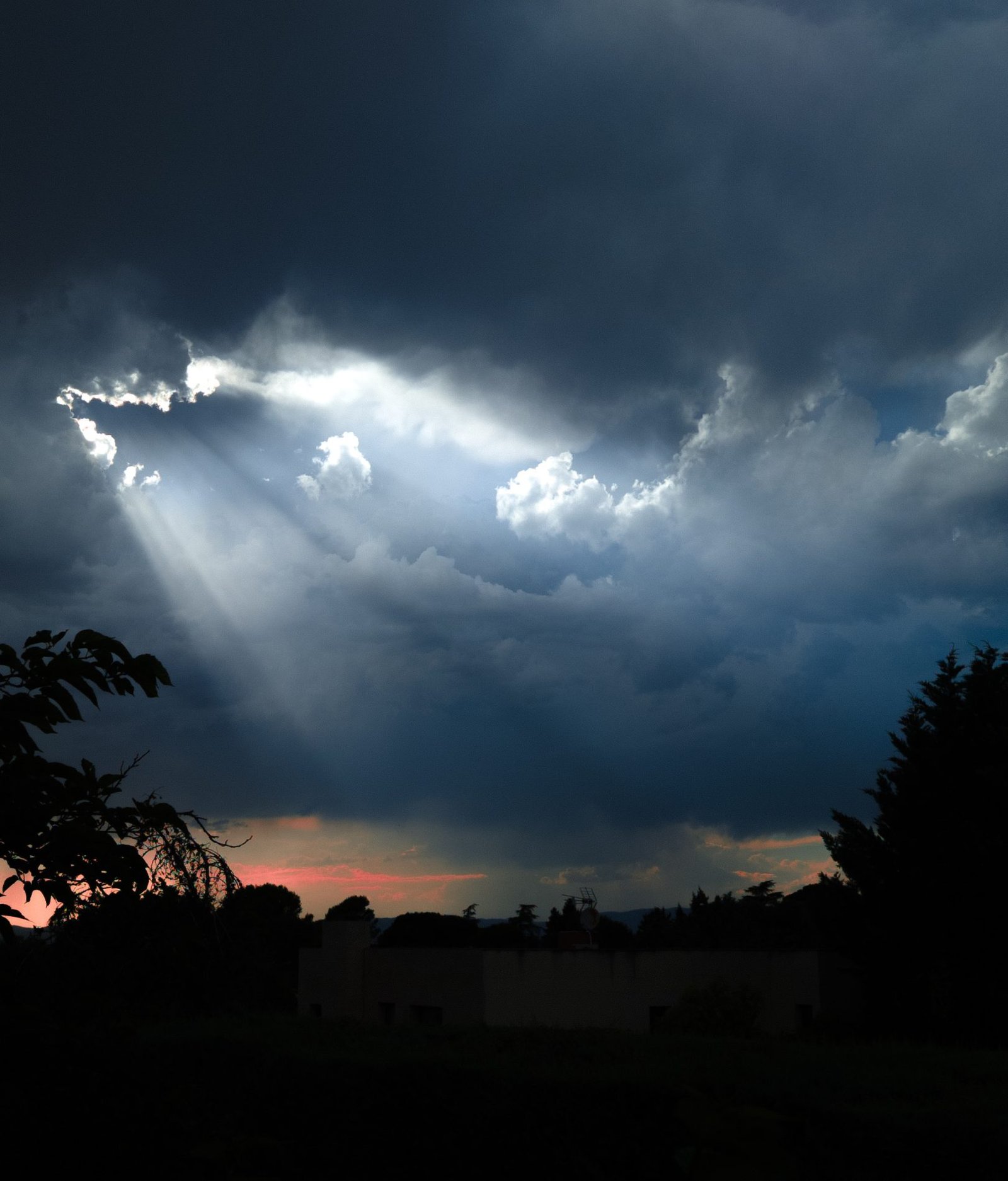 Tormenta al atardecer con rayos de luz entre las nubes